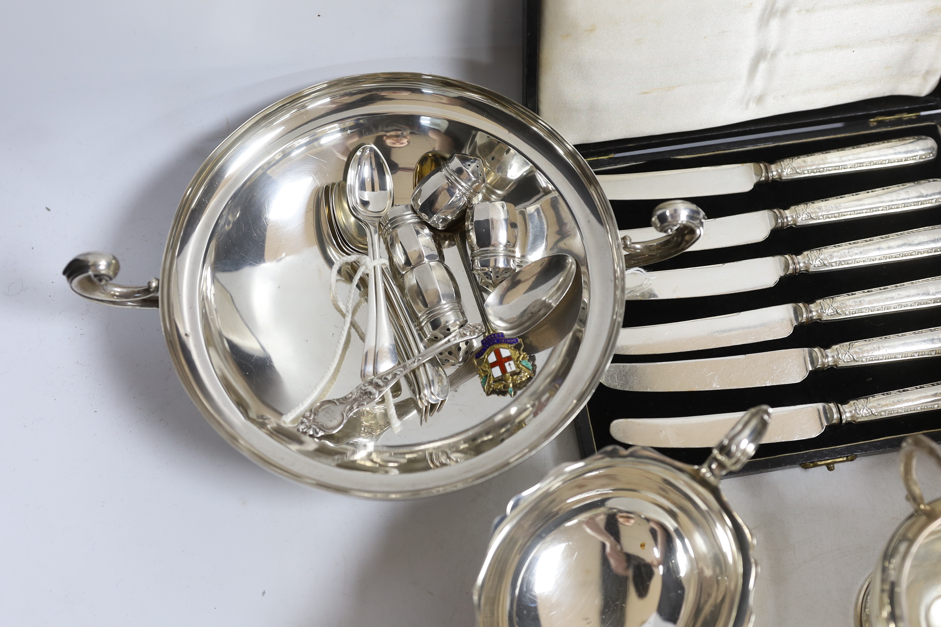 A small collection of silver including a sauceboat, two handled shallow bowl, five teaspoons and a commemorative spoon, together with a sterling cream jug and sugar bowl, sterling flatware and set of four pepperettes, to